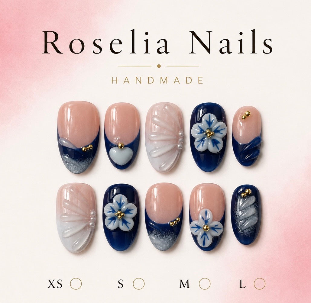 Navy almond nails with sculpted white blossoms and gold beads